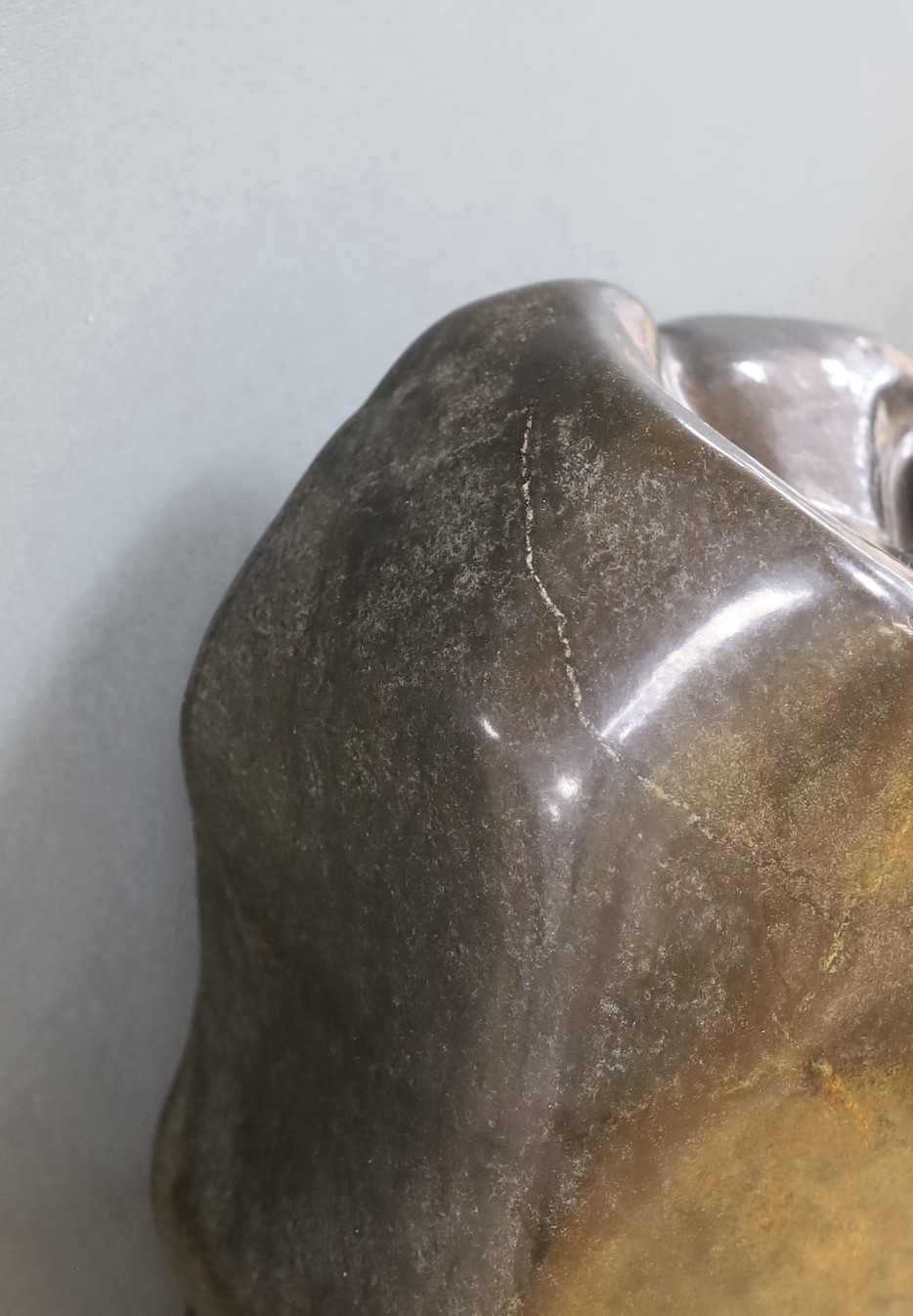 A Zimbabwean carved and polished stone abstract study of a crouching figure, 55cms.